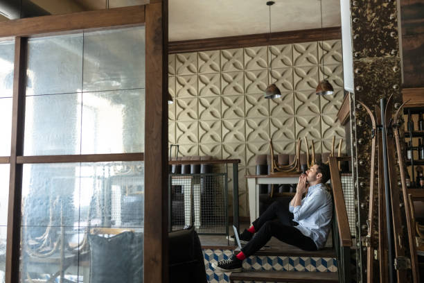 High angle view of man having breakfast sitting at table and talking with woman cooking by kitchen in a glamping house