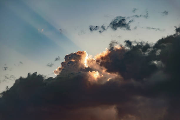 istock the sun shines through thunderclouds and beams of light fall on the blue sky 1220409912