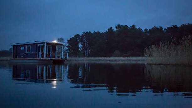 house boot on the lake at night with some lights