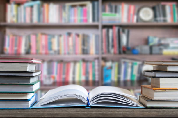 Books and textbook on wooden desk in library selective focus , Piles of books on reading desk in school with copy space for text.World book day and education concept. stock photo