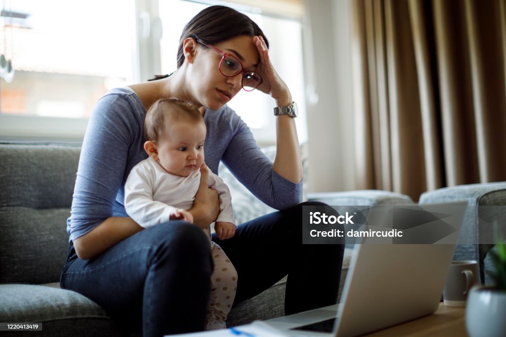 Tired young mother working from home Mother Stock Photo