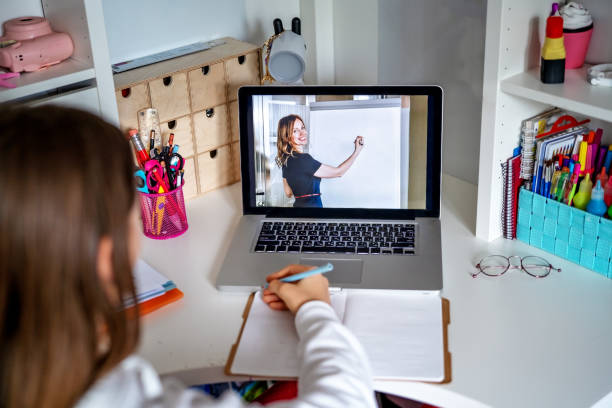 Teacher giving lesson online on video chat. Teenager girl studying at home looking at tutor at laptop screen during quarantine isolation period. Home schooling. Social distancing. Focus on coach profesor dando lección en línea en video chat. adolescente que estudia en casa mirando a tutor en la pantalla del ordenador portátil durante el período de aislamiento de cuarentena. la educación en casa. distanciamiento social. concéntrese en el entr