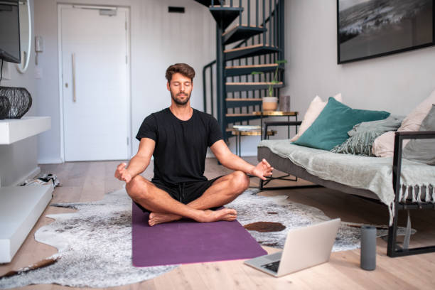Meditation. Handsome young man meditating in the living room bodyweight training stock pictures, royalty-free photos & images