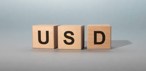 istock Wooden cubes with word USD on grey blue blue table 1220413951