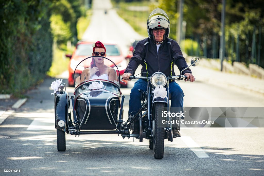 Bride Riding To Wedding Ceremony in an Old Sidecar Motorcycle Bride Riding To Wedding Ceremony in an Old Sidecar Motorcycle. Sidecar Stock Photo