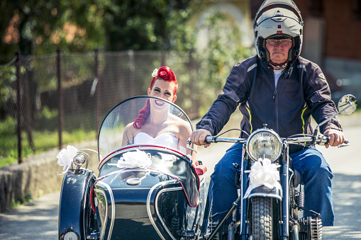 Smiling Bride Sitting in Sidecar of an Old Motorcycle on Her Way to Get Married.