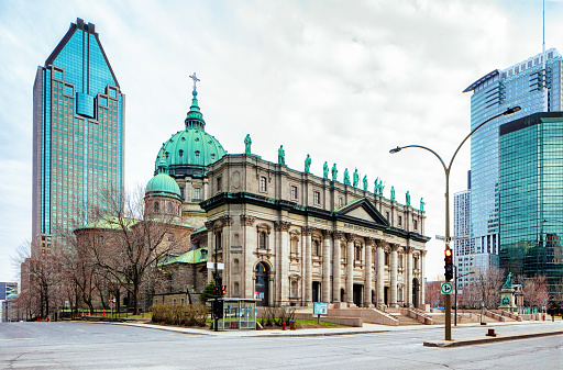 Montreal Mary Queen of The world cathedral wide shot with surrounding buildings photographed on an overcast day during the Covid crisis, hence with nobody in the frame.