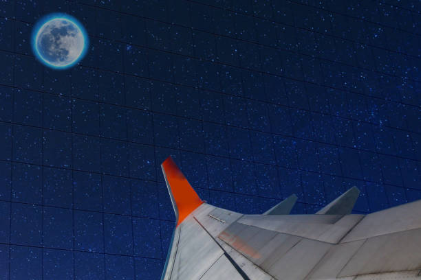 istock airplane wing points to moon in starry night sky 1220420634