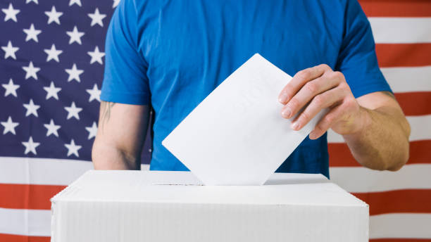 istock Hand with ballot and box in USA 1220421527