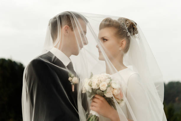 istock bride and groom hugging with tender under veil, luxury elegant wedding walk 1220421883