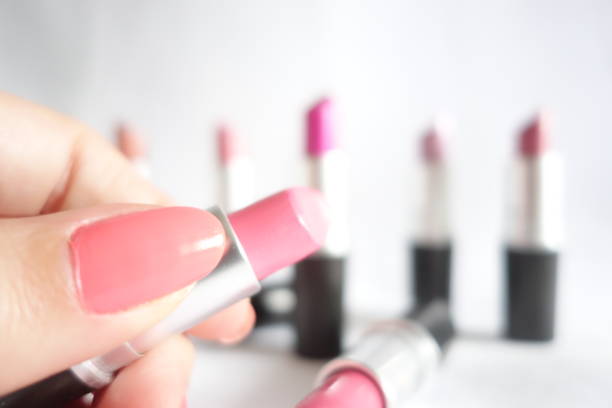 istock Woman hand holding pink lipstick on a white background 1220423116
