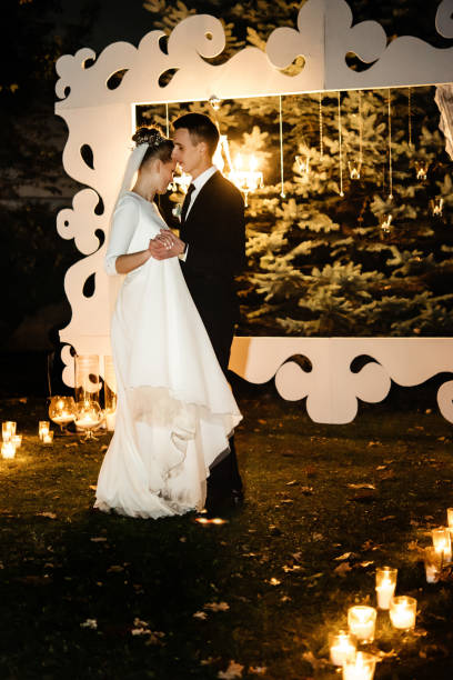istock gorgeous bride and stylish groom having their first dance at romantic candle light at evening wedding ceremony 1220425007