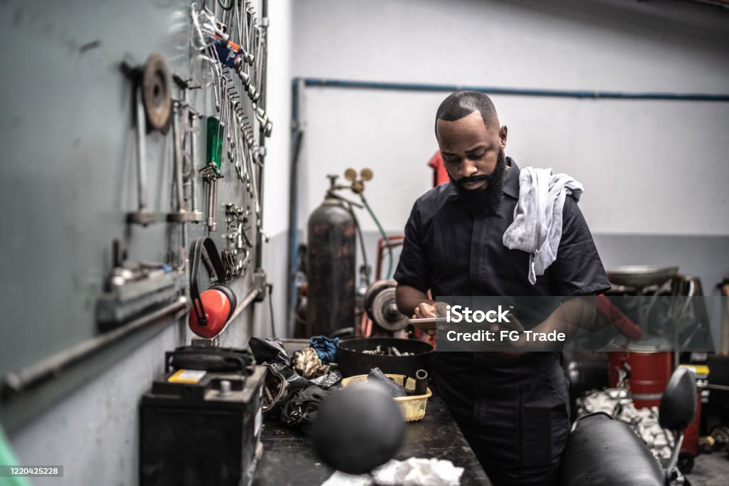 Man working with tablet in auto repair Car mechanics, workers, customers, satisfaction / Auto car repair service center. Owner Stock Photo