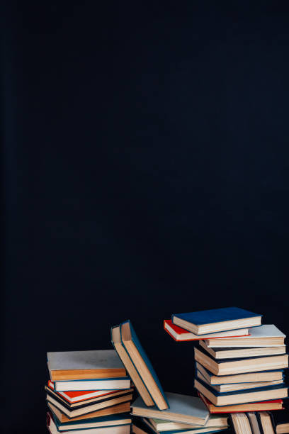istock many stacks of educational books in the university library on a black background 1220427759