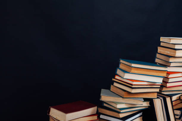 istock many stacks of educational books in the university library on a black background 1220427874