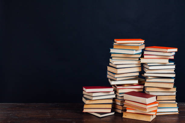 istock many stacks of educational books in the university library on a black background 1220428015