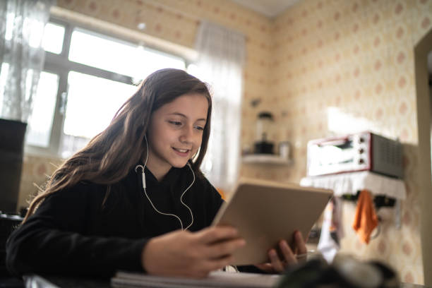 istock Girl making a video call / watching via tablet at home 1220428213