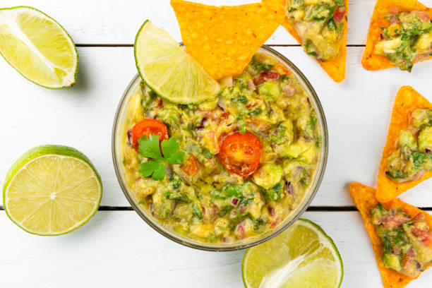 istock Tortilla chips and container with guacamole. Traditional Mexican food concept 1220430938