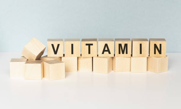 palabra de vitaminas sobre cubos de madera. concepto de medicina - organic single word environment block fotografías e imágenes de stock