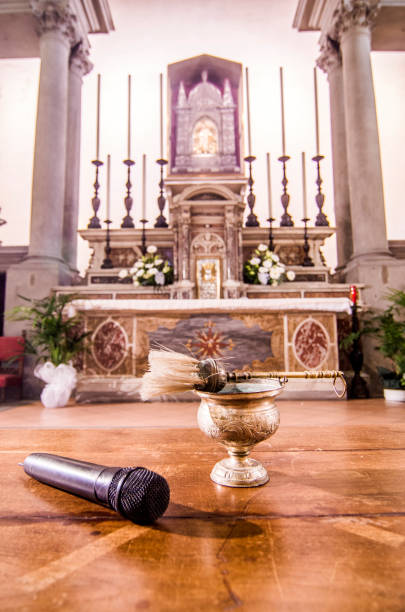 l’eau bénie et le microphone prêts à commencer la messe et à accueillir les fidèles, les croyants et le monde entier - the crucifixion audio photos et images de collection