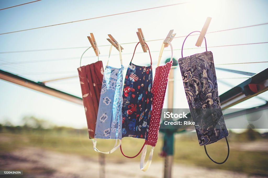 Self-sewn mouth-nose masks against corona viruses hang on the clothesline to dry. Protective Face Mask Stock Photo