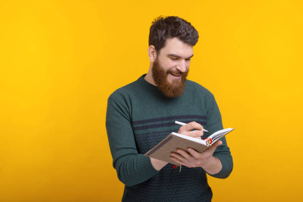istock handsome young man write in agenda, manage your time 1220434472