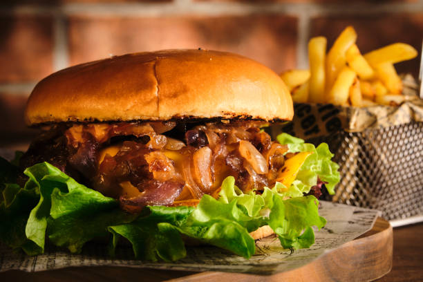 istock Burger with beef and caramelized onions on a wooden board. Cheeseburger with onion and beef. Juicy Delicious Homemade Burger. 1220435183