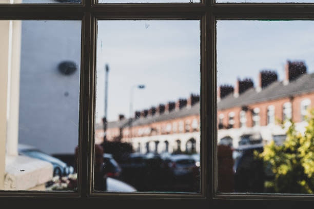 Viewpoint from interior of house through panels of front door towards front yard Viewpoint from interior of house through panels of front door  towards front yard and street beyond.  Selective focus.  Belfast, Northern Ireland. looking out front door stock pictures, royalty-free photos & images