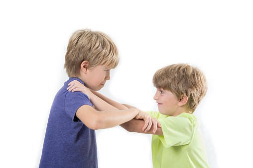 Two kids fighting, siblings, friends fight isolated on a white background, studio