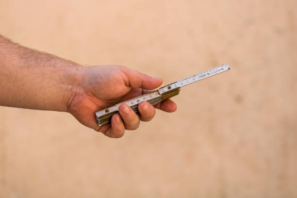 istock Tools for repair and building. Hand holding a ruler on blurred background 1220438389