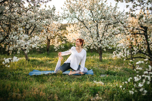 istock Woman Exercising Yoga in Orchard 1220439280
