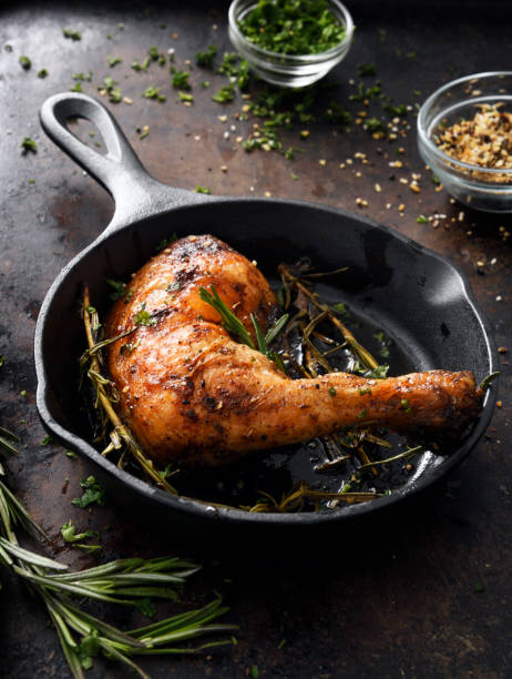 Chicken leg in a skillet Roasted barbecue chicken leg with seasoning in cast iron skillet crunchy photos stock pictures, royalty-free photos & images