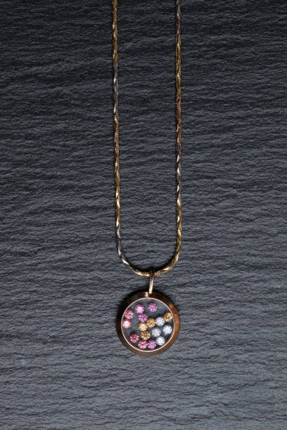 istock Pendant with colored rhinestones on a black stone table. Vertical. Top view. 1220440600