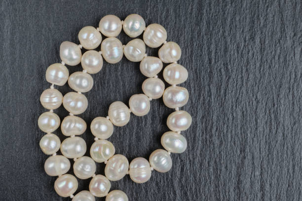 istock Pearl necklace on a stone table. Top view. 1220441864