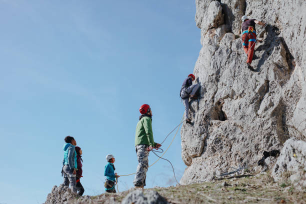 two man climbs a rock with rope. sport climbing, lead. - rock climbing fotos imagens e fotografias de stock