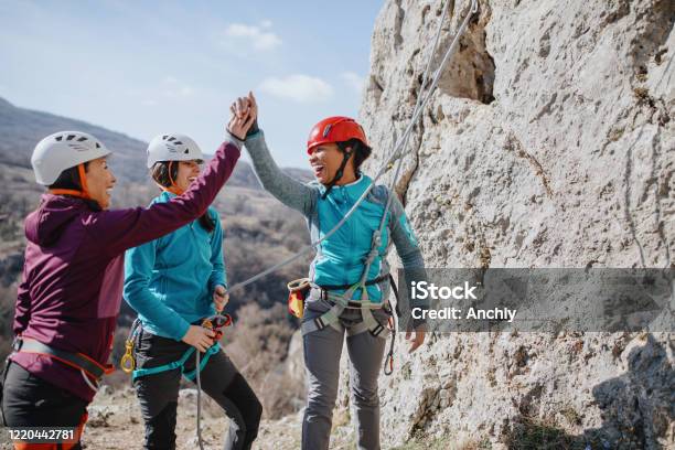 Climbers Giving High Fives After Successfully Finishing Climb Stock Photo - Download Image Now