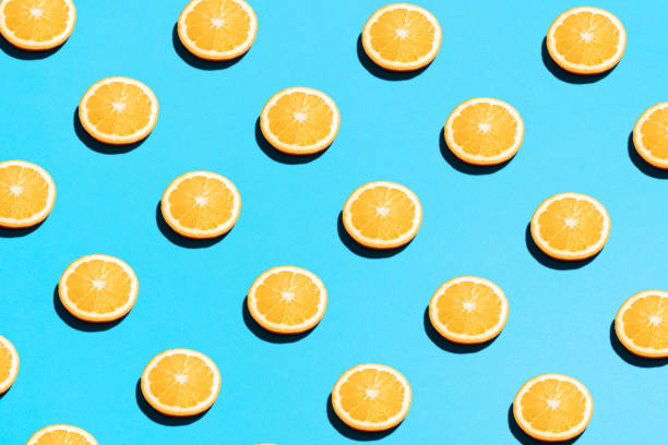 istock Orange pattern on bright light blue background. Minimal flat lay food texture. Summer abstract trendy fresh concept 1220443222