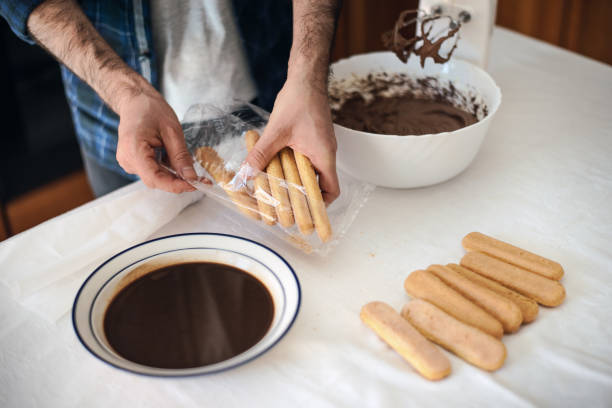 istock Quarantine cooking: a man cooks a tiramisu using an electric mixer, chocolate, biscuits and coffee 1220444300