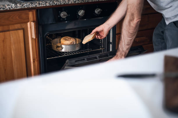 istock Quarantine cooking: a man is toasting bread in the oven 1220446972