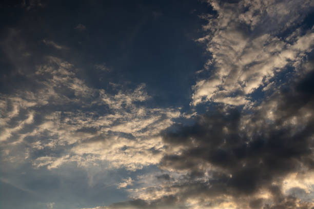 istock sheet of white clouds shaded with gray, floating over the rooftops and under the twilight sky. 1220446986