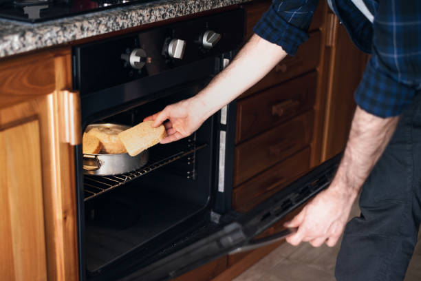 istock Quarantine cooking: a man is toasting bread in the oven 1220448321