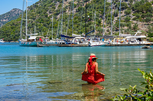 Woman in red dress in the bay.