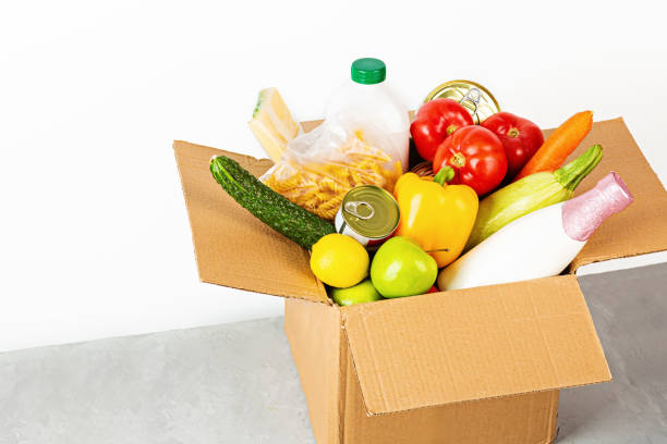 istock Donation box with various smart food on white background with copy space. Mockup. Food donations or food delivery service concept. Online shopping during coronavirus covid-19 lockdown 1220453199