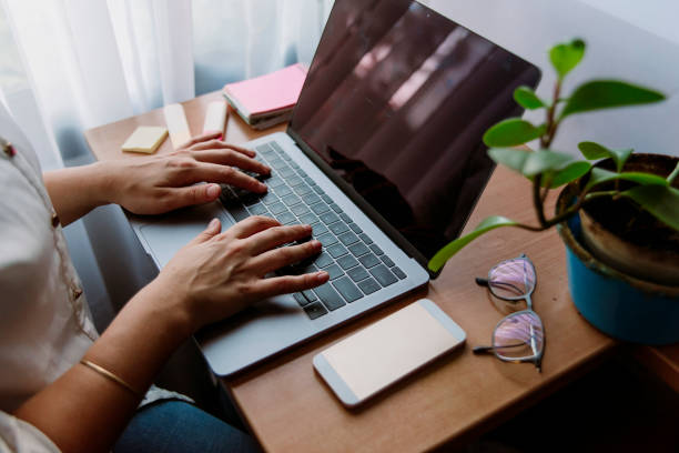 istock hands of girl writing in computer in office desk 1220453910