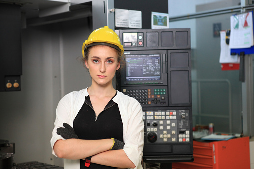 Female Industrial Engineers with  machine. Assist production engineer in industry.  her checking and  control flow of process in production. Concept Successful of Work.