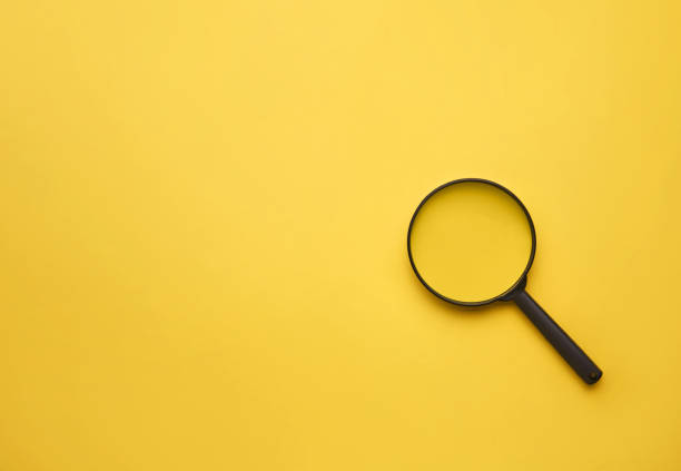 istock Magnifying glass on yellow background 1220457036