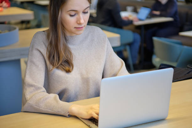 istock A girl in a restaurant is working on a laptop and typing. 1220458087