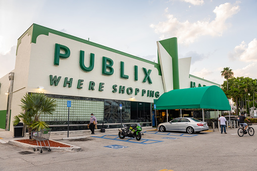 In Miami Beach, United States the Publix supermarket in an Art Deco building is open during the Coronavirus pandemic a customers wearing a mask can be seen leaving the grocery store.