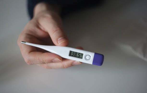 istock Man holding thermometer with 38.5 degrees. High temperature. Close up 1220459830