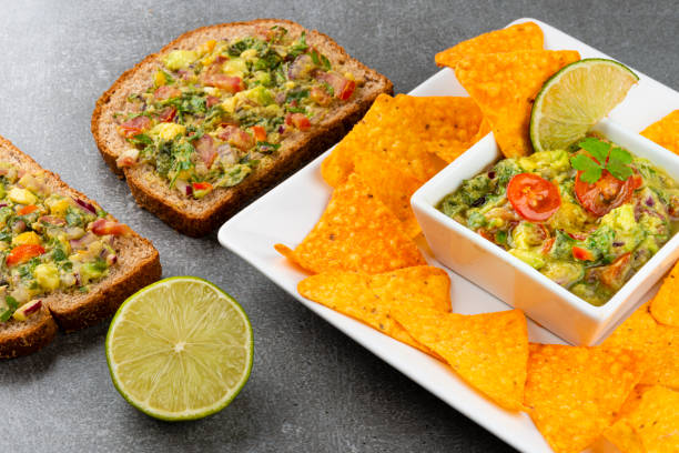 istock Avocado dip guacamole with tortilla chips and whole grains on gray stone 1220459947
